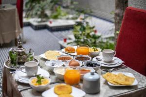 einen Tisch mit Frühstückszutaten und Orangensaft darauf in der Unterkunft Riad Dari Fes in Fès