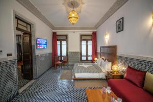 ein Schlafzimmer mit einem Bett und einem Sofa in einem Zimmer in der Unterkunft Riad Dari Fes in Fès