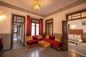 - un salon avec un canapé rouge et un lit dans l'établissement Riad Dari Fes, à Fès