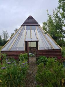 a greenhouse with a glass roof in a garden at Lakeview Retreat 