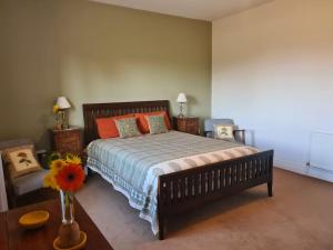Lakeview Retreat : غرفة نوم مع سرير مع وسائد برتقالية وطاولة
