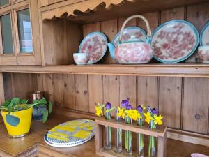 una estantería de madera con platos y flores sobre una mesa en Lakeview Retreat, 