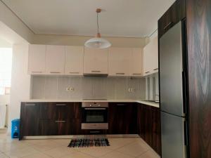 a kitchen with wooden cabinets and a refrigerator at Alimos seaview apartment in Athens