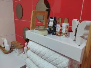 łazienka z półką z kosmetykami i lustrem w obiekcie Ivančica w mieście Aljmaš