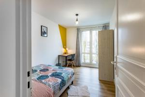 1 dormitorio con cama y escritorio con ventana en Résidence Bonaparte en Laval