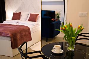 - une chambre avec un lit et une table ornée d'un vase de fleurs dans l'établissement Cherub Apartment, à Wrocław