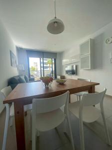 uma cozinha com uma mesa de madeira e cadeiras brancas em BArenales Sun Apart em Arenales del Sol