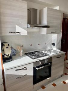 a kitchen with a stove and a sink at L'Aurora Guest House in Castellammare di Stabia