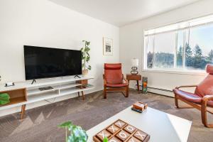 a living room with a large flat screen tv at THE ROGUE WAVE-Beach Access, Ocean Views, Private in Kodiak