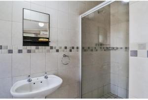 een badkamer met wastafel en douche met spiegel bij St Lucia Safari Logde Holiday Home in St Lucia +4 foto's