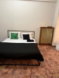 - une chambre avec un grand lit et des oreillers verts dans l'établissement Pink Flat Exarcheia Athens Netflix, à Athènes
