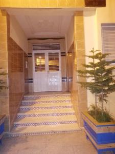 a front door of a building with a tree in front at Appartement Fes très propre et calme in Fez