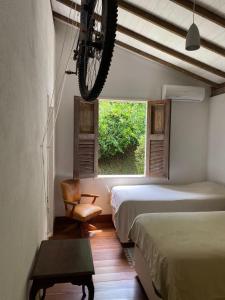 een kamer met twee bedden en een fiets die aan het plafond hangt bij Chez nous in Petrópolis