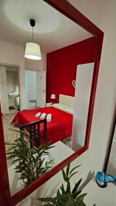 a mirror reflection of a bedroom with a red bed at Etnea Glamour House in Catania