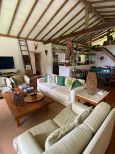 een woonkamer met witte banken en een tafel bij Chez nous in Petrópolis