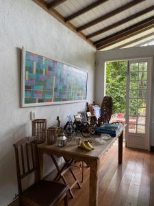 een kamer met een tafel met stoelen en een schilderij aan de muur bij Chez nous in Petrópolis