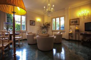 a living room with couches and a chandelier at Hotel Atlantico in Castiglioncello
