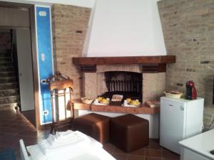 uma cozinha com uma lareira de tijolos e um fogão em B&B Il Centralino em Legnaro