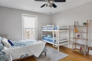 a bedroom with two bunk beds and a ceiling fan at Dubuque's Front Porch, Historic Charmer, Walk Downtown in Dubuque