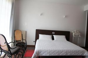 um quarto com uma cama e duas cadeiras em B&B Il Centralino em Legnaro