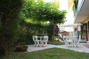 un grupo de sillas y mesas en un jardín en B&B Il Centralino, en Legnaro