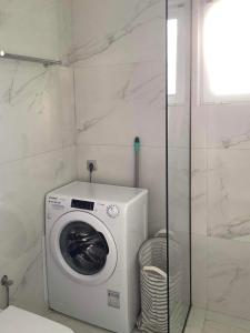a washing machine in a bathroom with a shower at Villa Maxima Lavrio in Thorikón