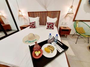um quarto com uma cama com uma bandeja de comida em L'Hédone, hôtel de charme em Ouagadougou