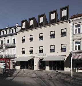 - un grand bâtiment blanc avec des fenêtres noires dans l'établissement Badhaus - Hotel/Restaurant/Café, à Bad Hall