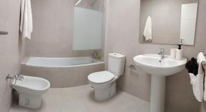 a white bathroom with a toilet and a sink at Kiana Mirador Jerez con parking in Jerez de la Frontera +19 photos