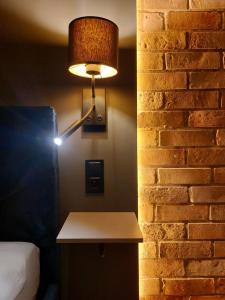 lámpara en una pared en una habitación con cama en FRIENDS House, en Gorzów Wielkopolski
