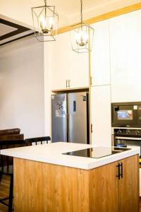 a kitchen with a white counter top and a refrigerator at Tanjung Jara Cottage - with indoor pool in Dungun