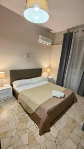 Un dormitorio con una cama grande y una lámpara. en Etnea Glamour House, en Catania