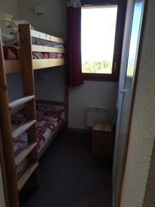 a room with two bunk beds and a window at Appartement valmeinier 6 personnes in Valmeinier