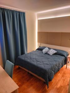 1 dormitorio con 1 cama con cortinas azules en Locanda La Lucciola, en Portovenere