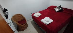 a red bed with two white towels on it at Departamento Independiente Quitilipi in San Salvador de Jujuy
