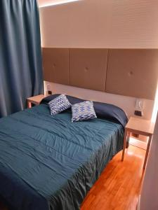 1 dormitorio con 1 cama con 2 almohadas en Locanda La Lucciola, en Portovenere