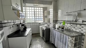 cocina con fregadero y lavavajillas en Apartamento no topo da Ilha Porchat, en São Vicente