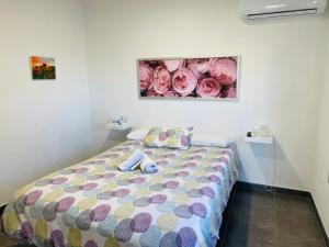 a bedroom with a bed with a colorful comforter at Vistas directas al volcán y piscina in El Paso