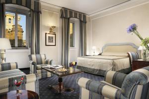 una camera d'albergo con un letto e delle sedie di Hotel De La Ville a Firenze