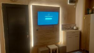 a tv on the wall of a kitchen with lights at Skopje Apartment in Skopje