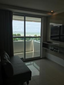 a room with a large window with a view of the ocean at Lindo Flat com vista mar João Pessoa in João Pessoa