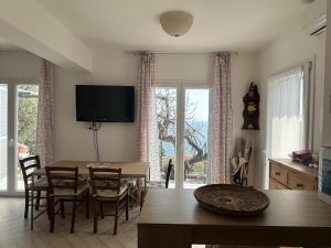 a dining room with a table and chairs and a television at Casa del sasso in Bergeggi