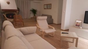 een woonkamer met een bank, een stoel en een tv bij Gaiko Etxe Berri in Aizarnazábal