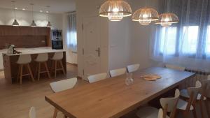 a kitchen and dining room with a wooden table and chairs at Gaiko Etxe Berri in Aizarnazábal