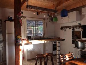 una cocina con barra y dos taburetes. en Hermoso lugar de descanso en Santa Ana a una cuadra de la playa, en Balneario Argentino