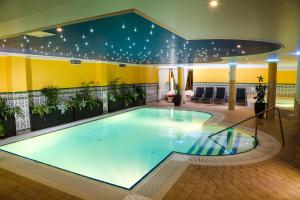 a large swimming pool in a building at Calimbra Wellness Hotel Superior in Miskolctapolca