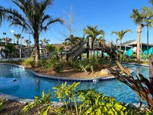 a resort pool with a wooden bridge and palm trees at Luxury 9BR Villa @ Storey Lake Resort Near Disney in Kissimmee