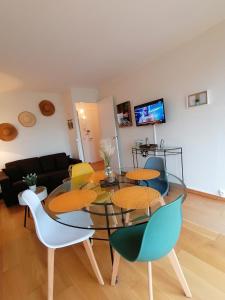 een woonkamer met een glazen tafel en stoelen bij Ô Pied Marin in Le Tréport