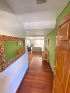 un pasillo con paredes verdes y blancas y una puerta en Mza Holiday Home en Mendoza