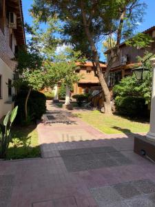 una pasarela a través de un patio con árboles y un edificio en Mza Holiday Home en Mendoza
